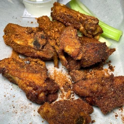 Crispy, seasoned chicken thighs with celery on the side.